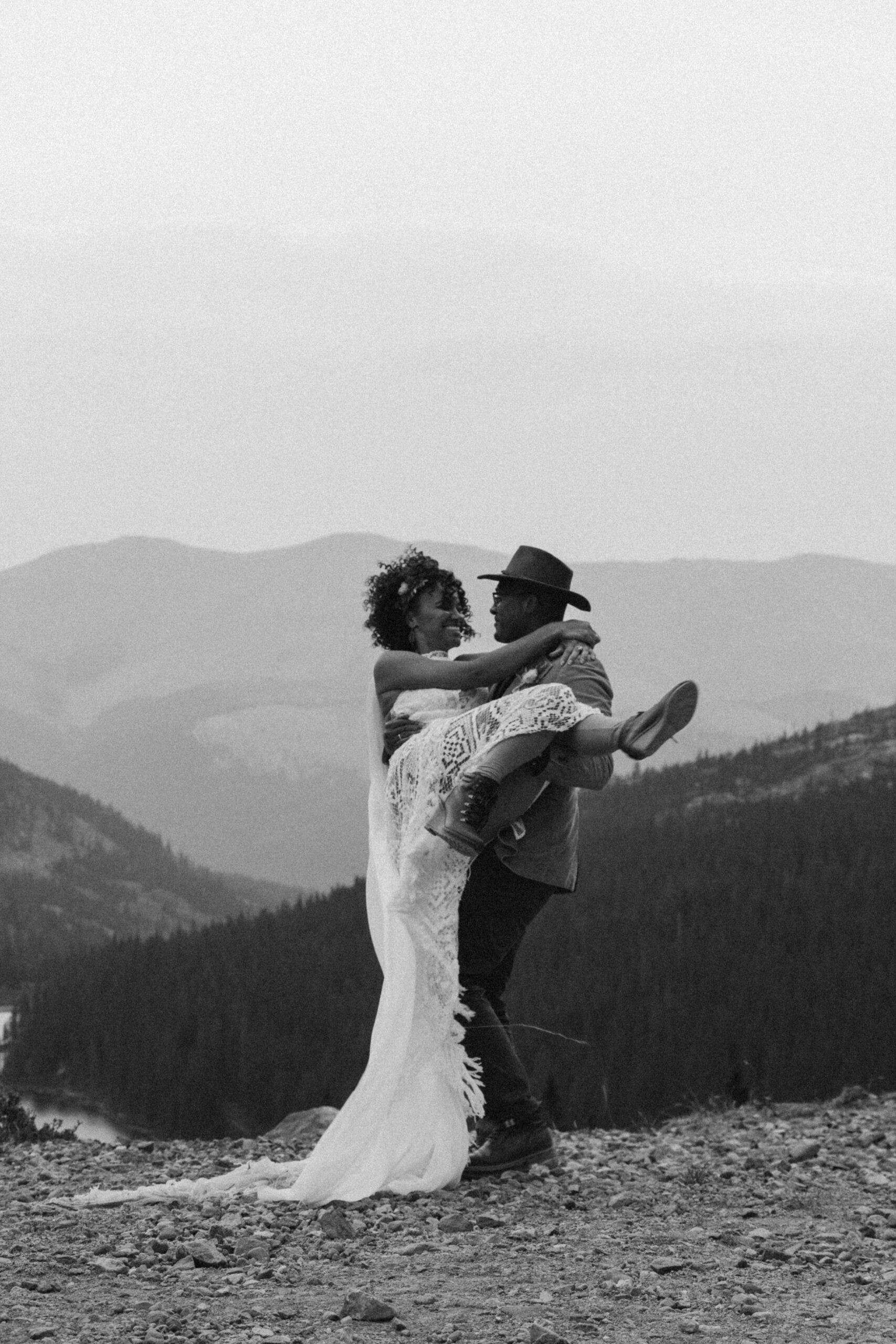 A man carries his bride while hiking in Colorado