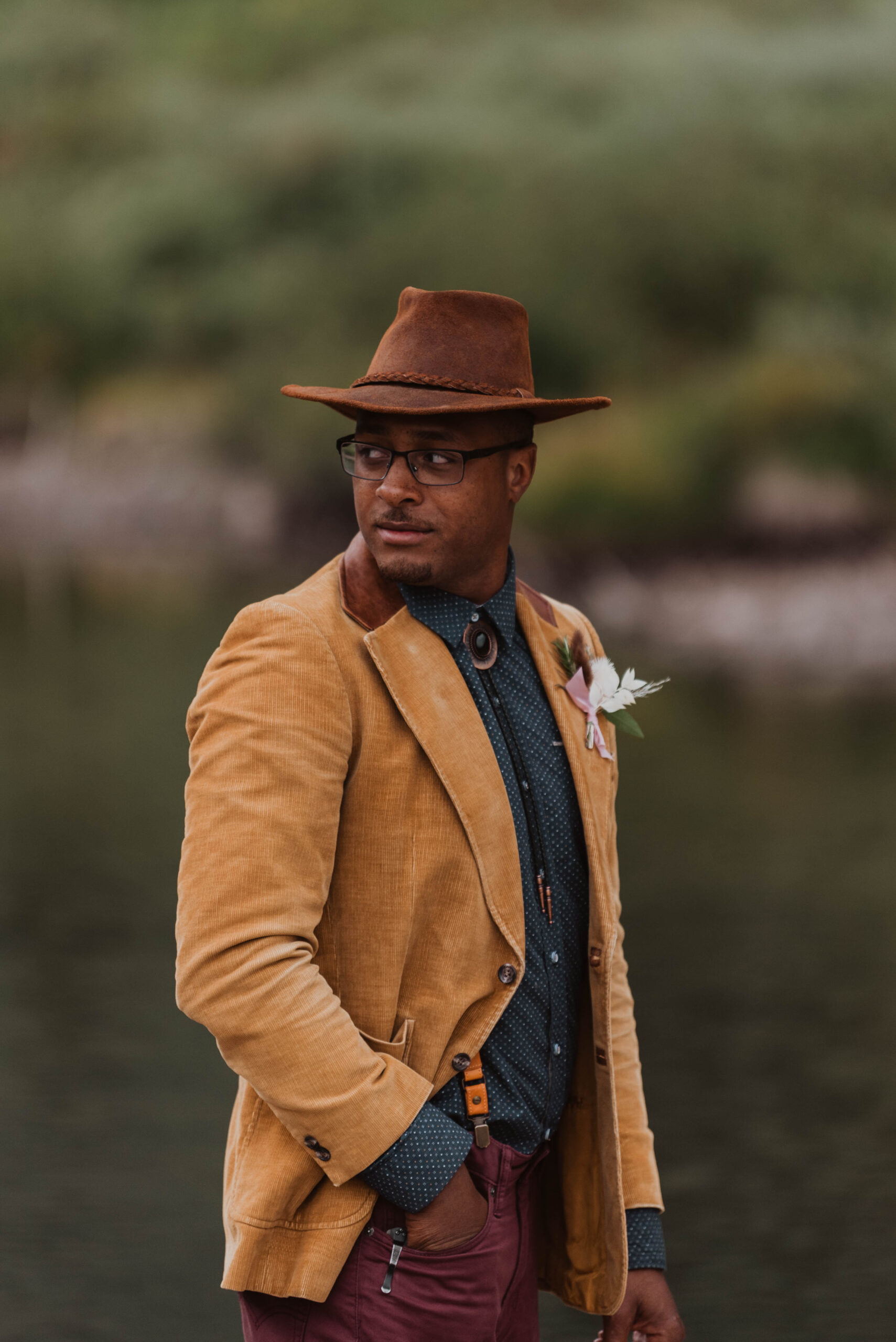 A man looks over his shoulder while on a hiking elopement