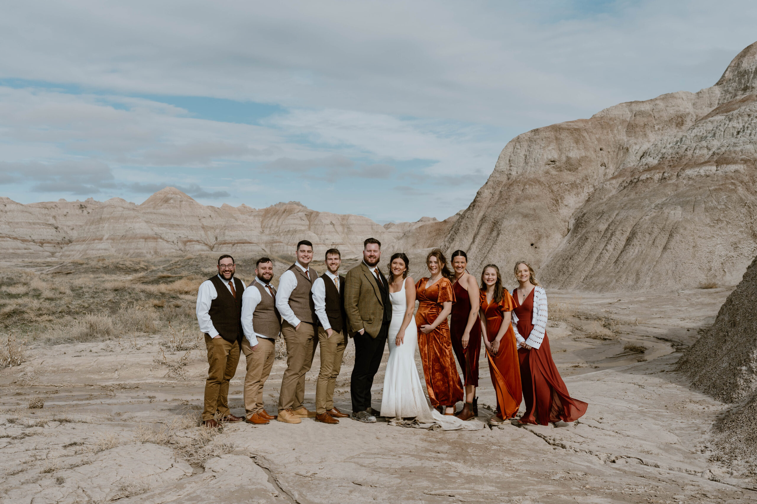 A wedding party poses for a photo in front of a canyon overlook