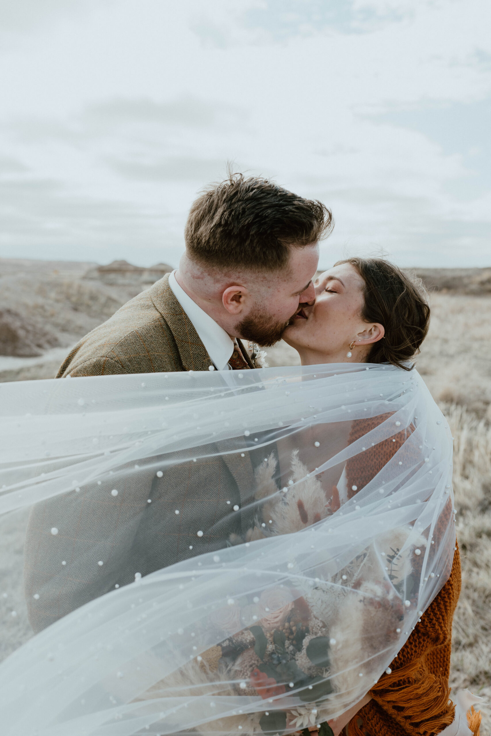 A couple kisses in Badlands National Park after their wedding