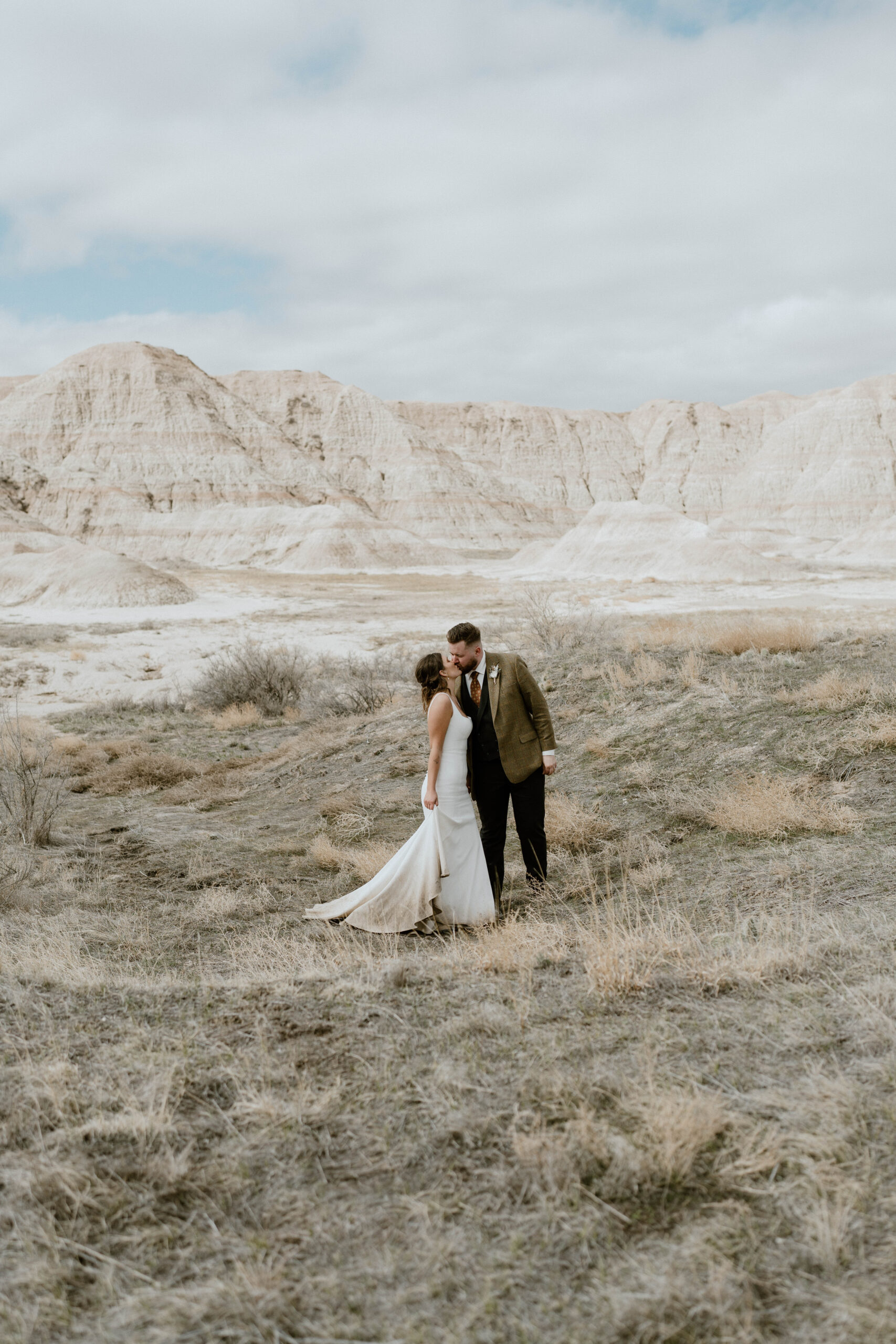 A newly married couple kisses in Badlands National Park