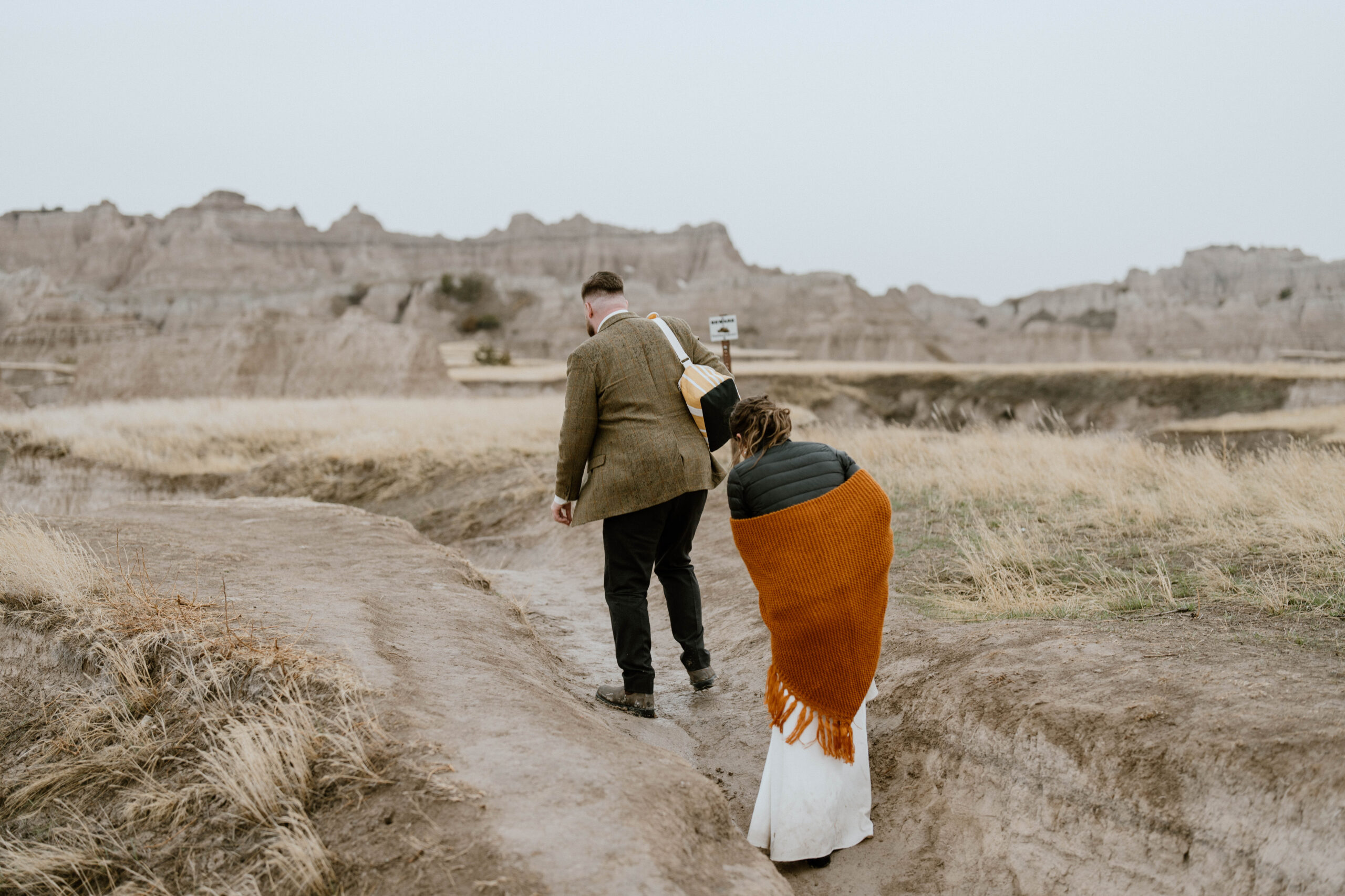 A couple hikes up to their picnic spot following an intimate national park wedding