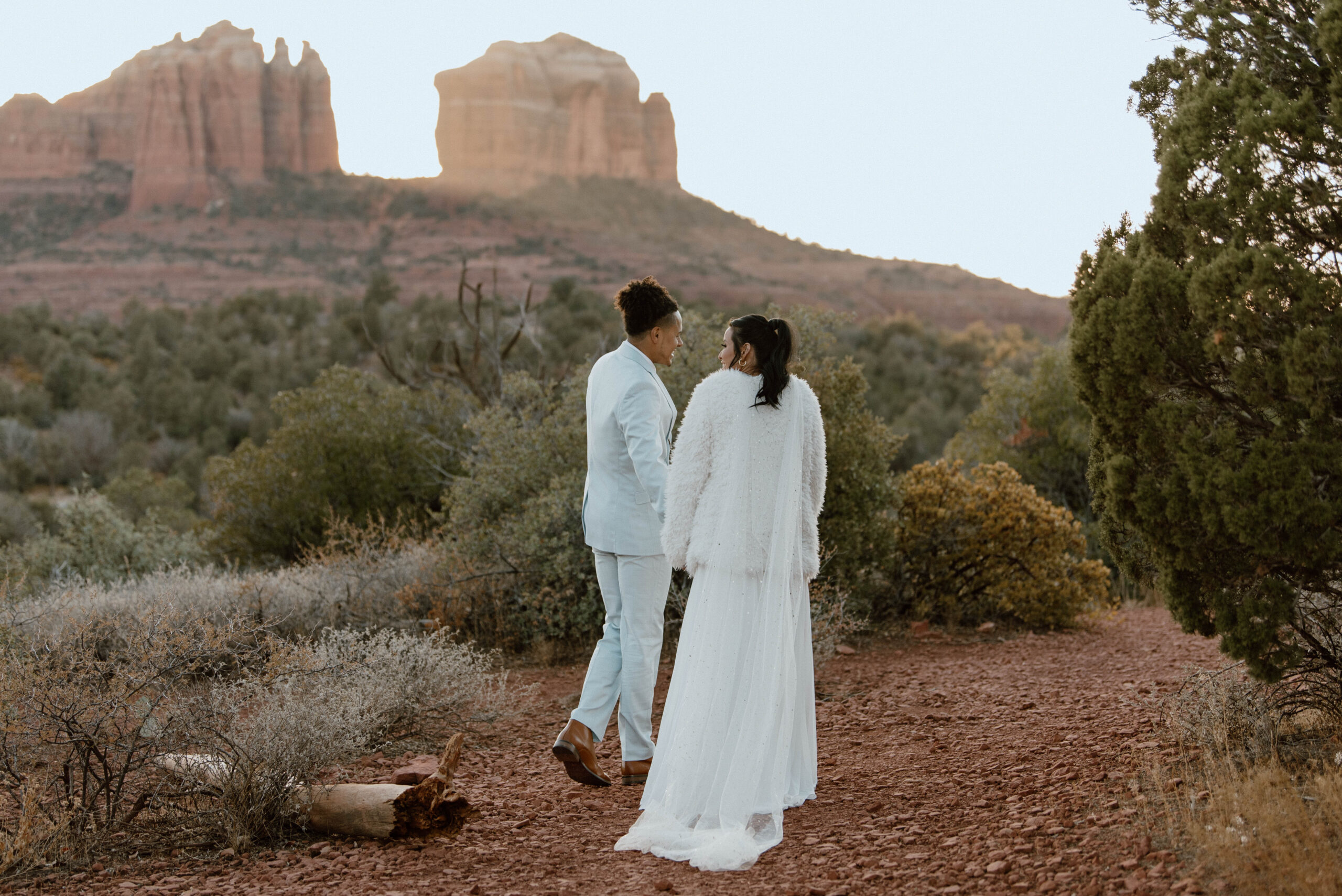 A couple walks hand and hand in the Arizona Desert in Sedona during their intimate wedding