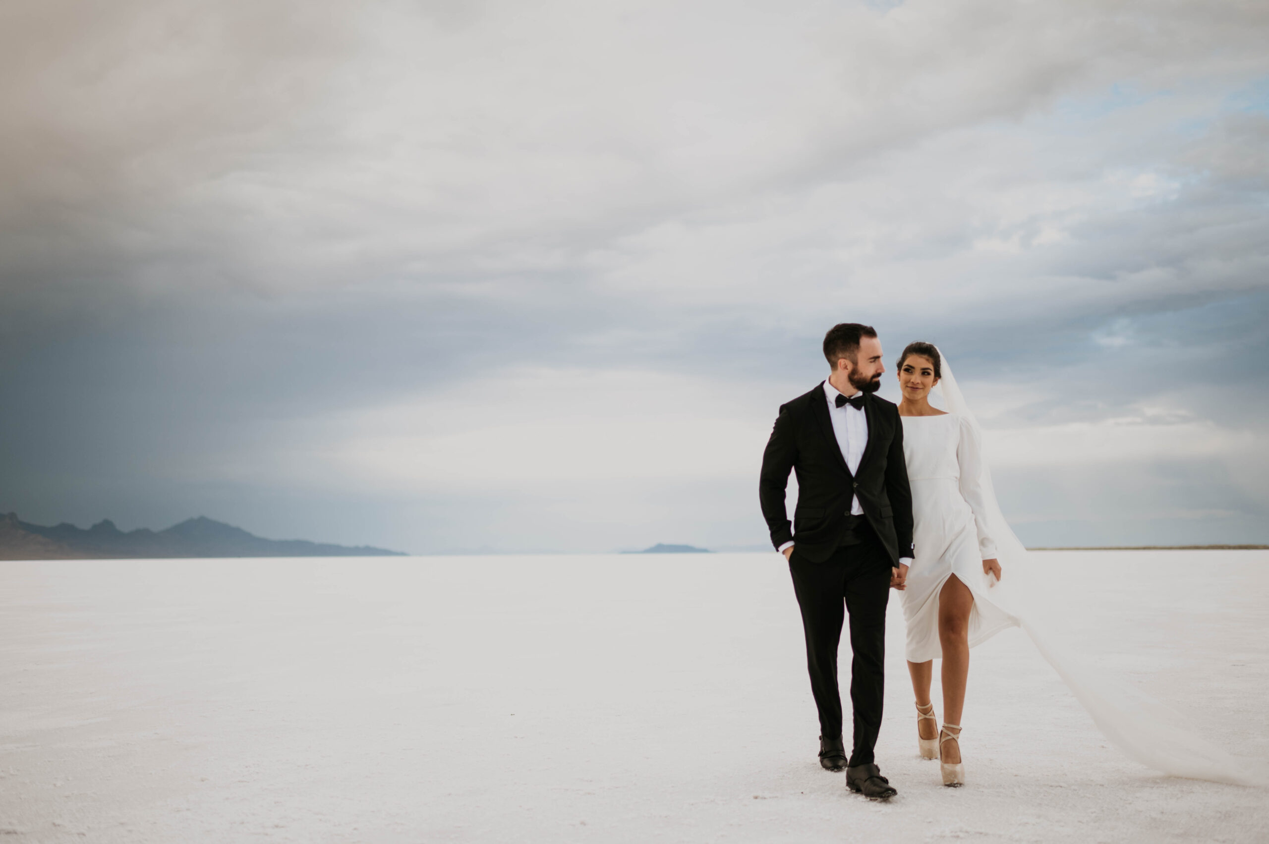 A newly married couple walks across the Salt Flats in Utah