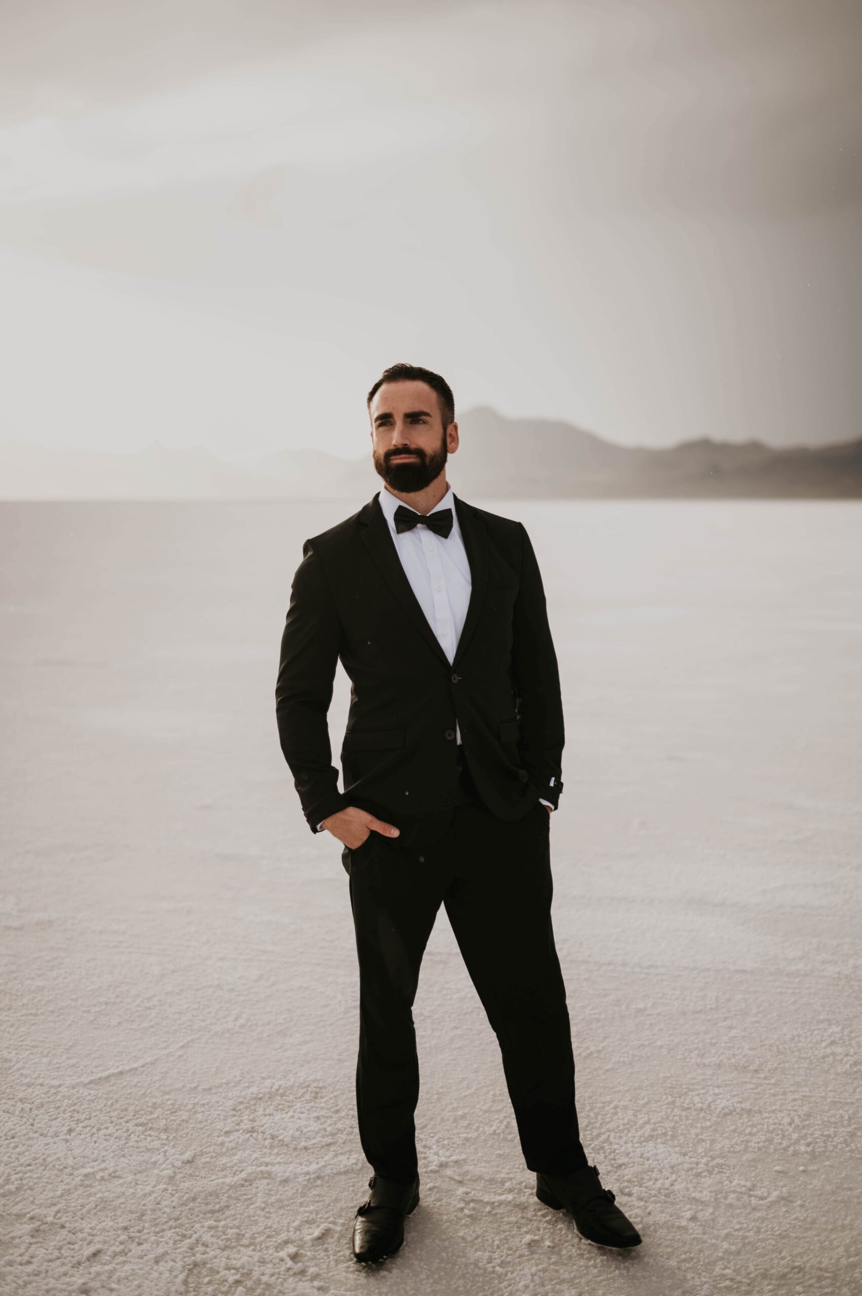 A man in a suit stands on the Salt Flats in Utah