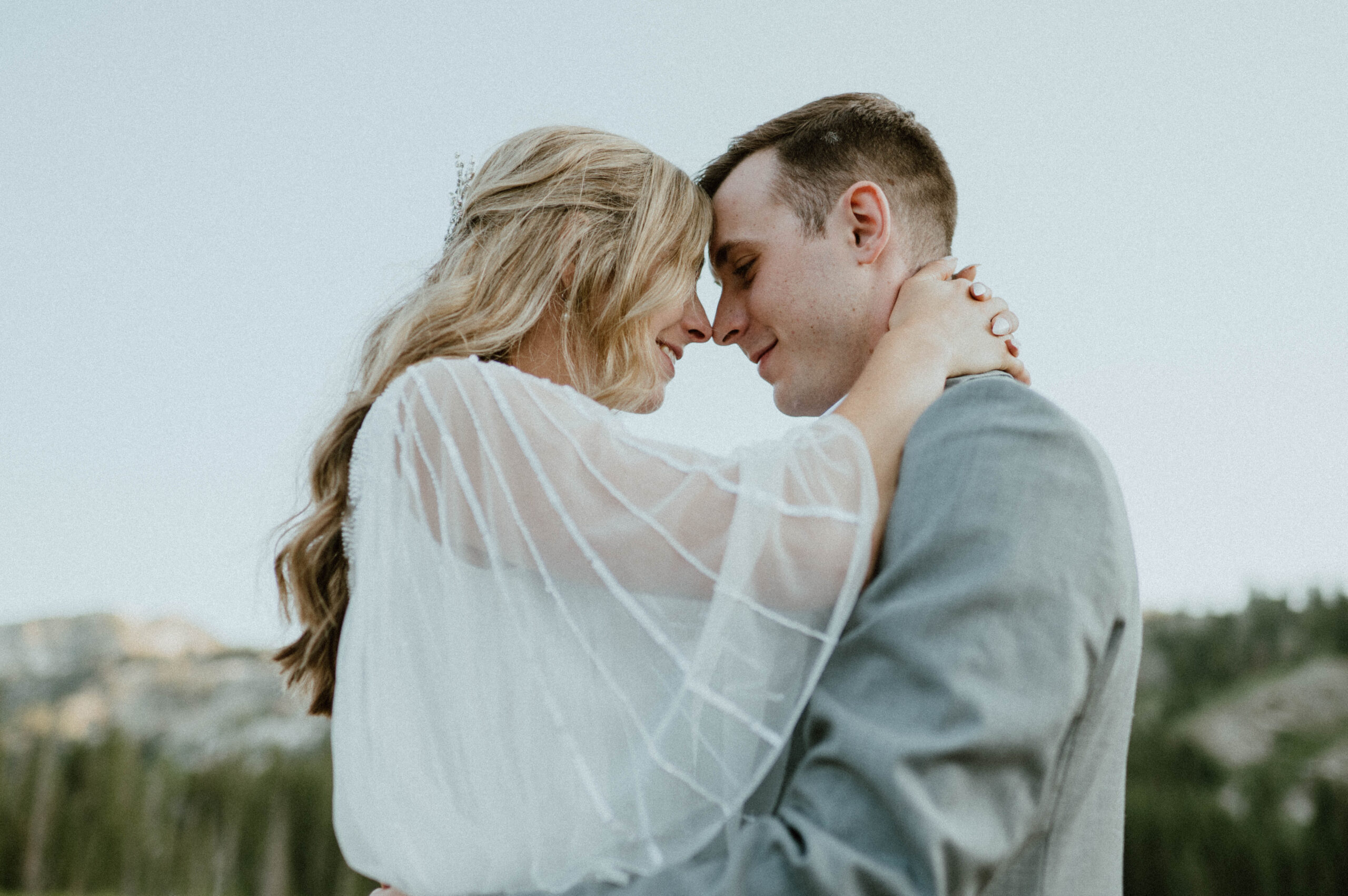 A bride and groom hold one another close in the mountains of Utah