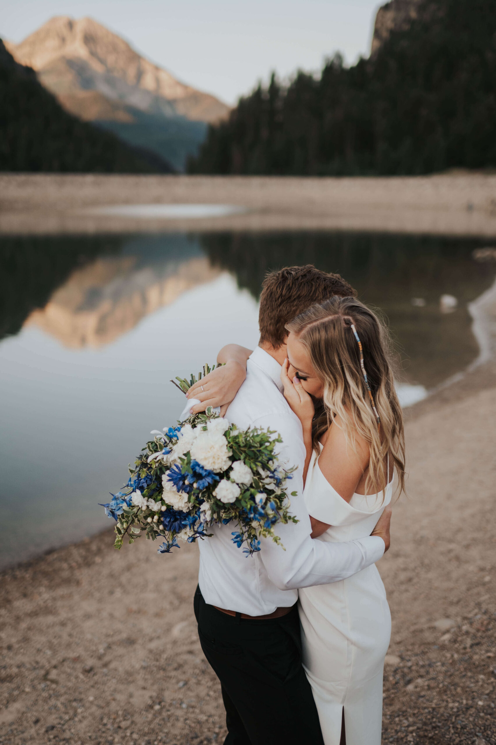 A couple hugs after getting married in Utah in the forest