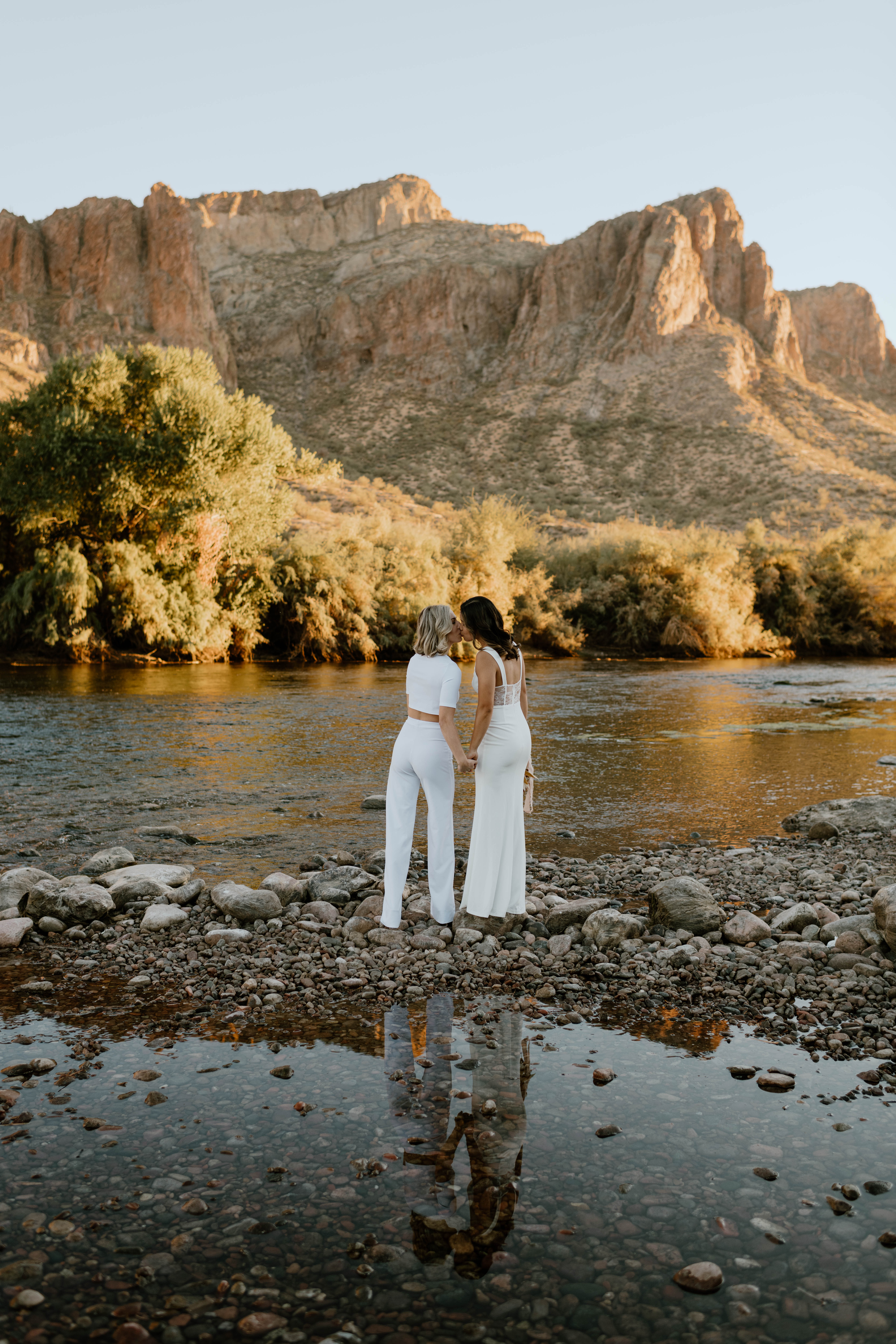 A couple embraces in wedding attire after their Sunset desert elopement