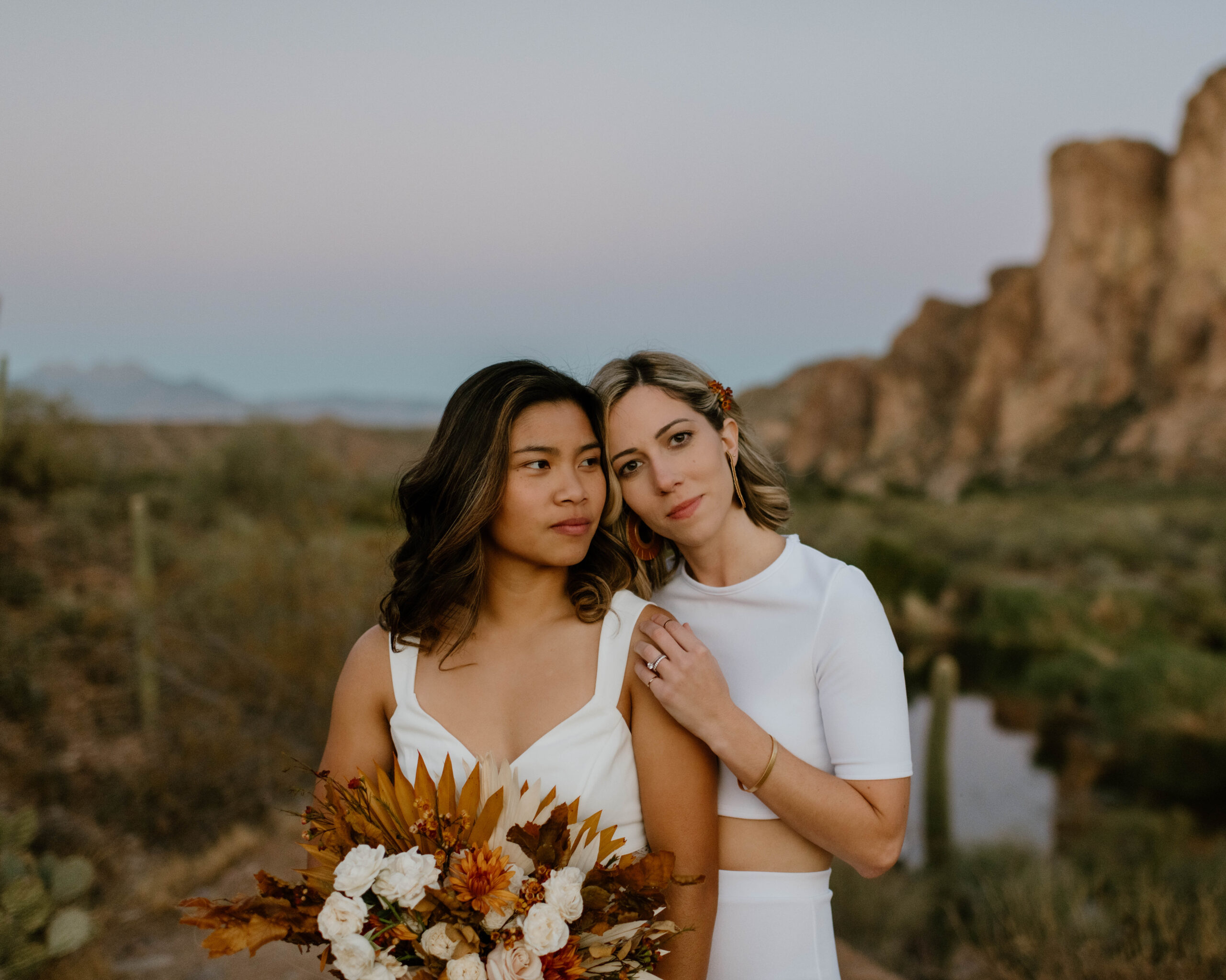 A woman looks into the camera as she holds her wife during their elopement in near Scottsdale